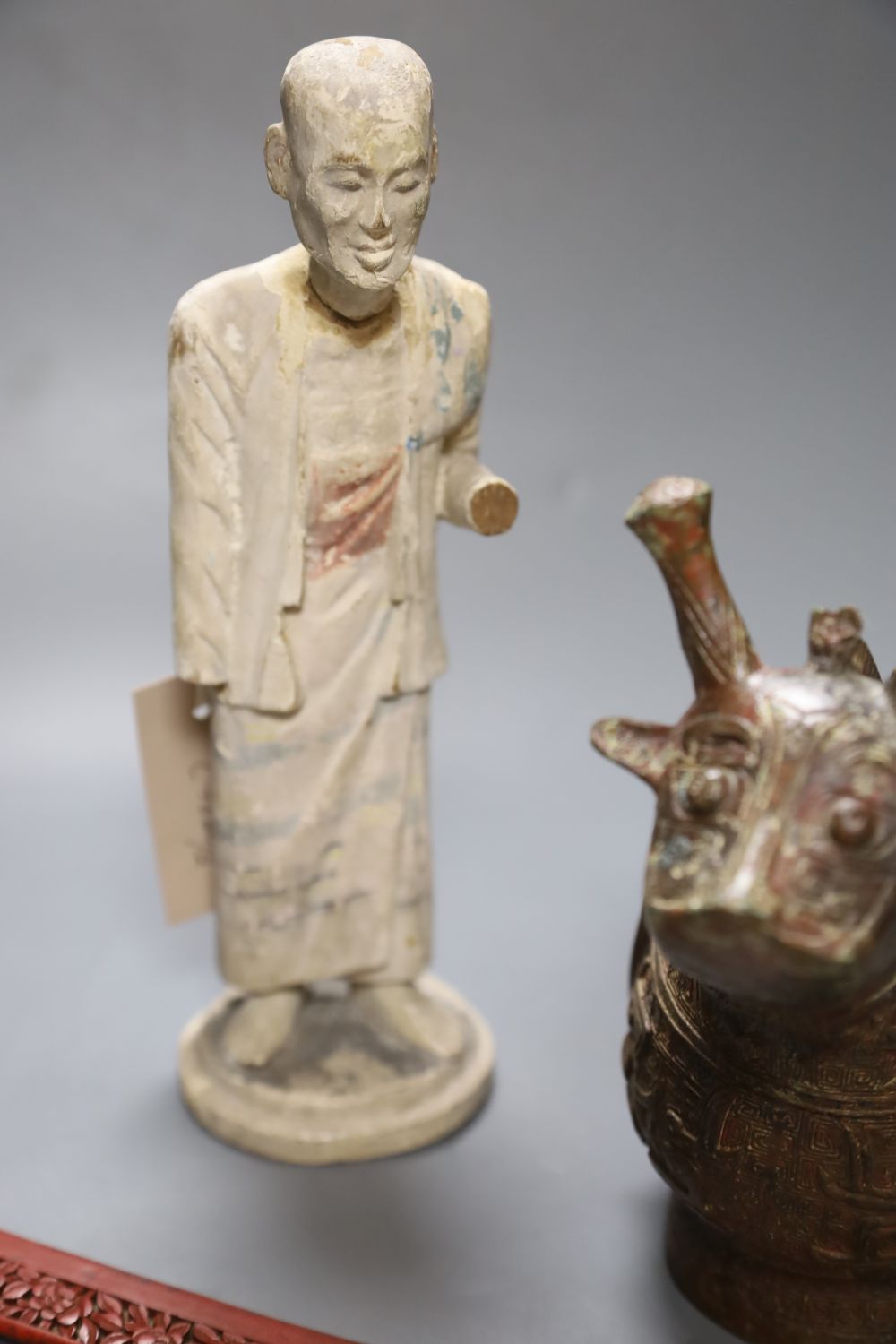 A Chinese archaistic bronze vessel, a Chinese carved wood figure and a cinnabar lacquer mount